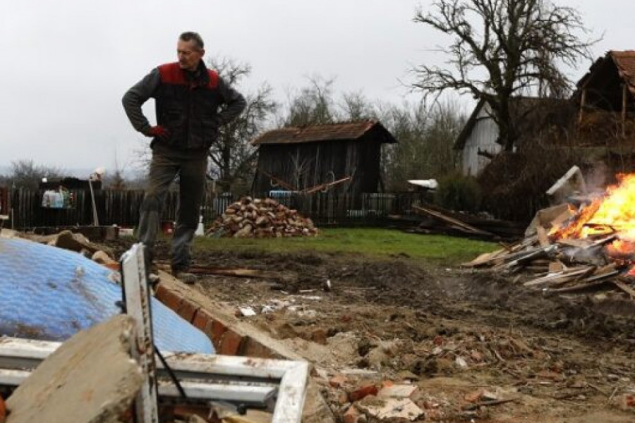epa08918705 A man stands in front his destroyed house and burns debris in the Majske Poljane village near Glina, 04 January 2021. The 6.4 magnitude earthquake that struck Croatia on 29 December 2020 left many houses in Petrinja, Sisak and the Glina area damaged or destroyed and another 4.2 magnitude aftershock was measured earlier on 04 January 2021. The 29 December 2020 earthquake left numerous people injuried and at least seven people dead.  EPA-EFE/ANTONIO BAT